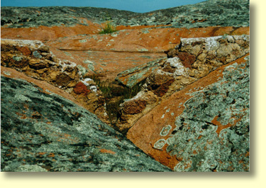 The Old dam wall was breached in 1928. Water from the dam was used in the construction of water gutters at the base of Pildappa Rock. The remains of the dam are located across centre frame. 